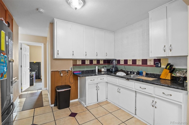 11192 E 7th Ave, Aurora, CO 80010 - kitchen featuring white cabinetry, light tile patterned floors, and freestanding refrigerator
