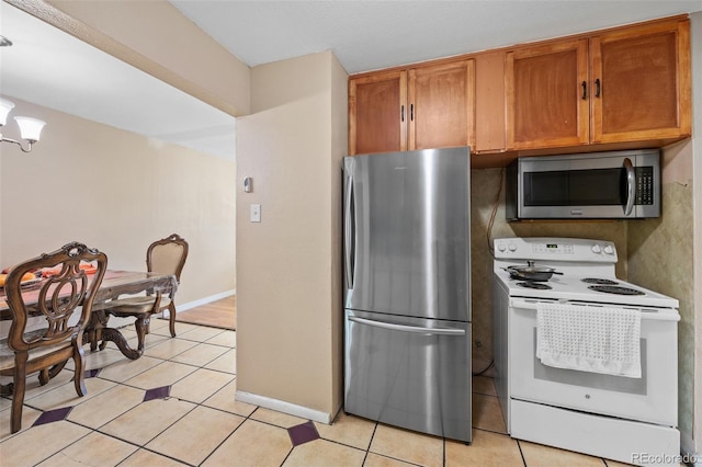 11192 E 7th Ave, Aurora, CO 80010 - kitchen with stainless steel appliances, brown cabinets, and light tile patterned flooring