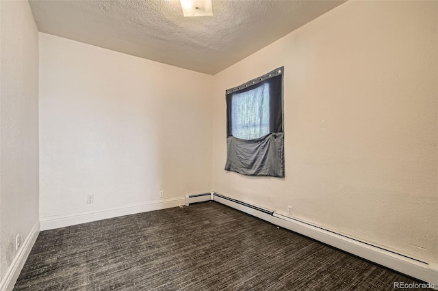 spare room featuring baseboards, a textured ceiling, and baseboard heating