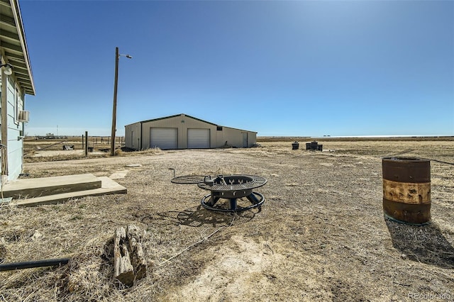 view of yard with a garage, a pole building, a rural view, and an outdoor structure