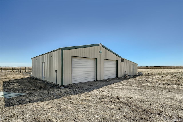 detached garage featuring fence