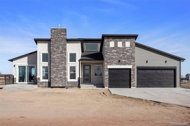 view of front facade featuring stone siding, a garage, driveway, and stucco siding