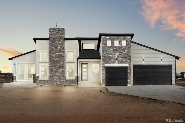 view of front of house with concrete driveway, an attached garage, stone siding, and stucco siding