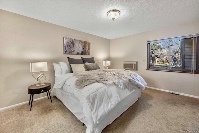 carpeted bedroom with baseboards, a wall mounted air conditioner, and a textured ceiling