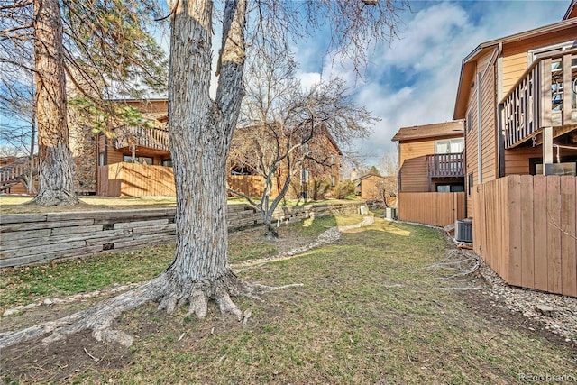 view of yard with central AC unit and fence