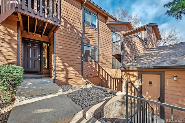 property entrance featuring a shingled roof