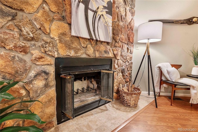 interior details with a fireplace, baseboards, and wood finished floors