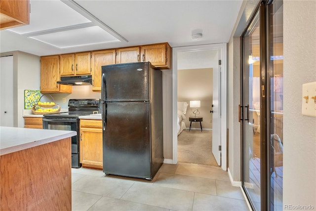 kitchen featuring light tile patterned floors, baseboards, light countertops, under cabinet range hood, and black appliances