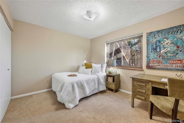 carpeted bedroom featuring baseboards and a textured ceiling