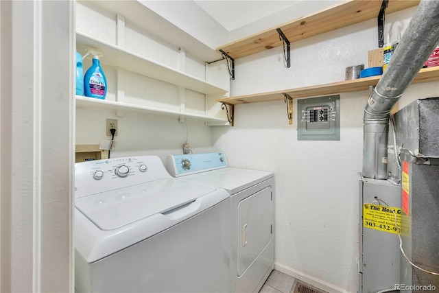 laundry area with electric panel, washing machine and dryer, laundry area, and light tile patterned flooring