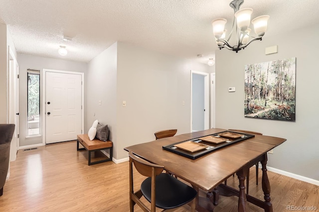 9411 W 89th Cir, Westminster, CO 80021 - dining space with a chandelier, light wood-style flooring, a textured ceiling, and baseboards