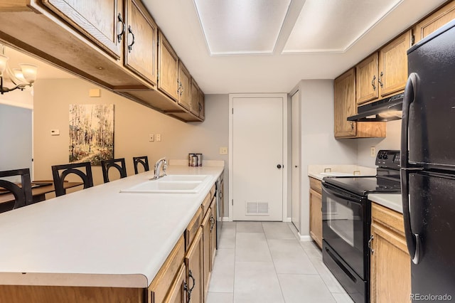 9411 W 89th Cir, Westminster, CO 80021 - kitchen with black appliances, under cabinet range hood, light tile patterned floors, a sink, and light countertops