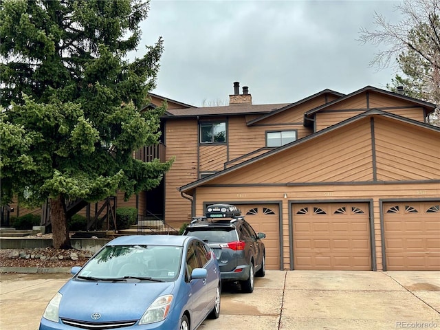 9411 W 89th Cir, Westminster, CO 80021 - view of front facade with concrete driveway, a chimney, and an attached garage