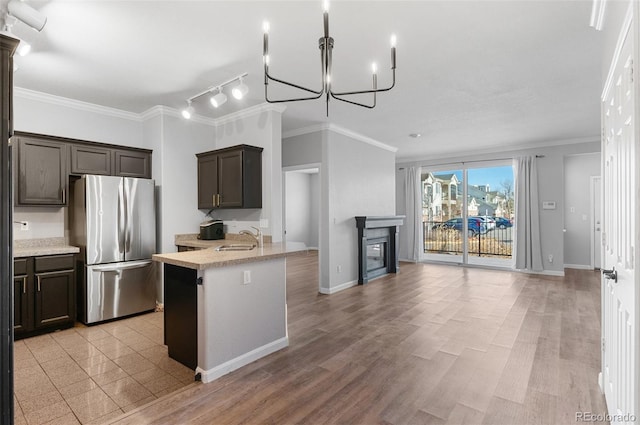 kitchen with stainless steel fridge, sink, and ornamental molding