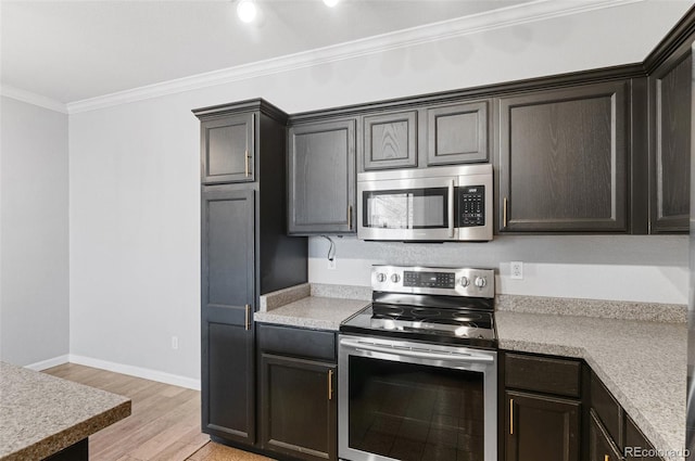 kitchen with dark brown cabinets, ornamental molding, appliances with stainless steel finishes, and light hardwood / wood-style flooring