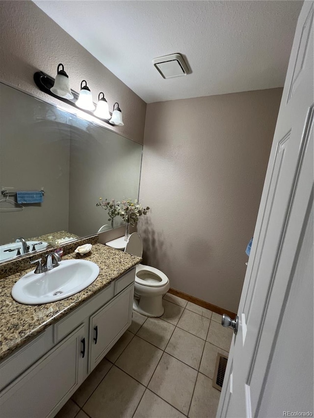 bathroom featuring tile patterned flooring, vanity, and toilet