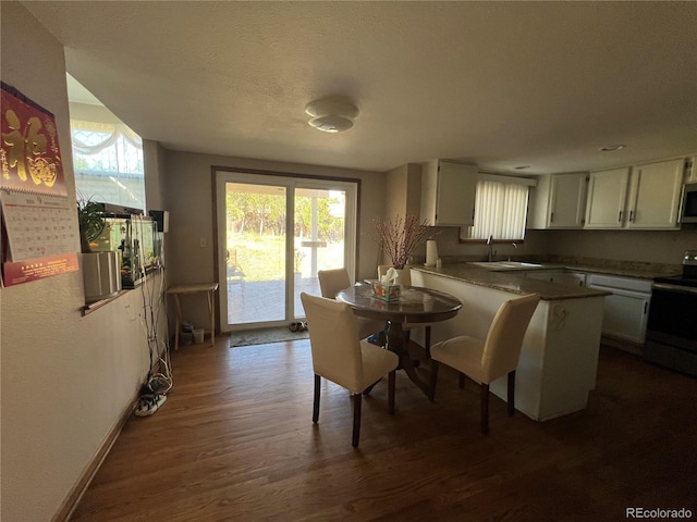 kitchen featuring white electric range, a wealth of natural light, sink, and white cabinets