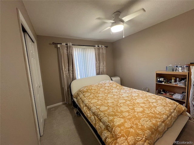 carpeted bedroom featuring ceiling fan and a closet