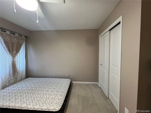 carpeted bedroom with ceiling fan and a closet