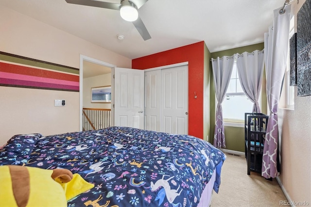 carpeted bedroom featuring ceiling fan and a closet