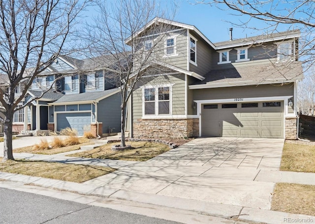 view of front of home featuring stone siding, an attached garage, and driveway