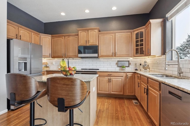 10251 Rifle St, Commerce City, CO 80022 - kitchen featuring light wood-style flooring, a sink, stainless steel appliances, glass insert cabinets, and light stone countertops