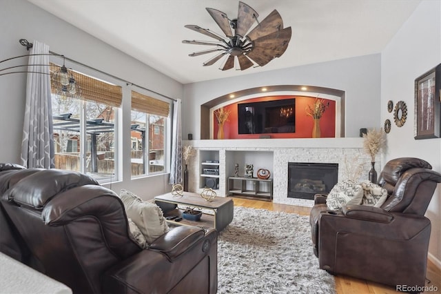 10251 Rifle St, Commerce City, CO 80022 - living room featuring a stone fireplace, wood finished floors, and a ceiling fan