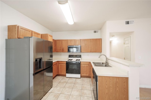 kitchen with stainless steel appliances, light countertops, visible vents, a sink, and a peninsula