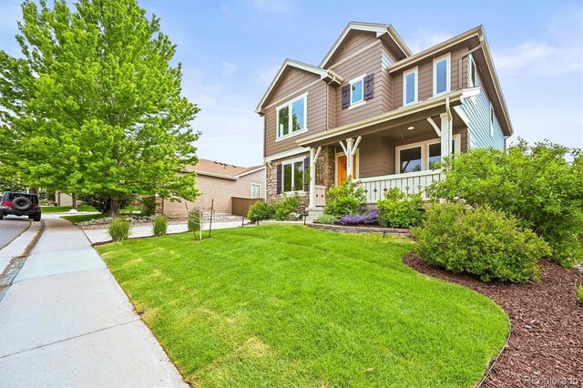 10235 Rustic Redwood Ln, Highlands Ranch, CO 80126 - craftsman inspired home with a porch, stone siding, and a front yard