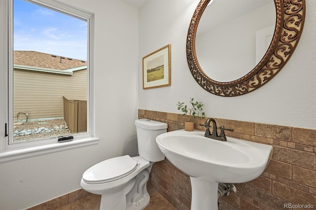 10235 Rustic Redwood Ln, Highlands Ranch, CO 80126 - bathroom with toilet, tile walls, and a wainscoted wall