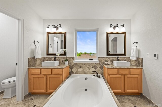 10235 Rustic Redwood Ln, Highlands Ranch, CO 80126 - full bath featuring two vanities, a garden tub, and toilet