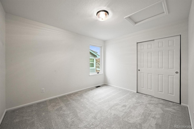 10235 Rustic Redwood Ln, Highlands Ranch, CO 80126 - unfurnished bedroom with attic access, carpet, baseboards, a closet, and a textured ceiling