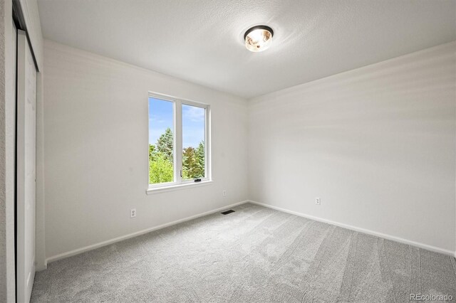 10235 Rustic Redwood Ln, Highlands Ranch, CO 80126 - carpeted empty room featuring baseboards and a textured ceiling