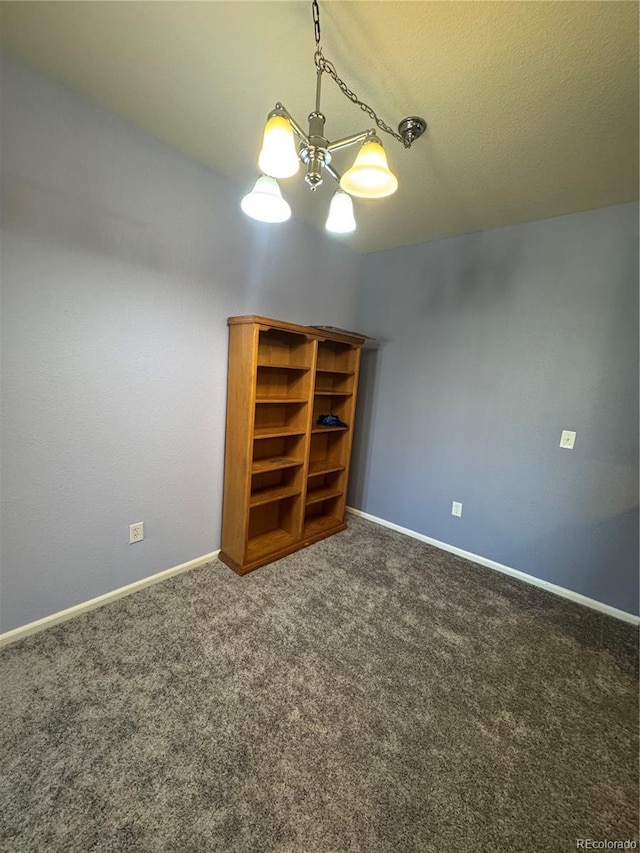 carpeted empty room with a textured ceiling and baseboards