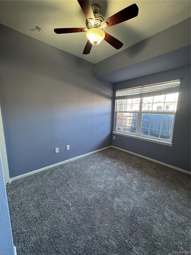 unfurnished room featuring dark carpet, a textured ceiling, and baseboards