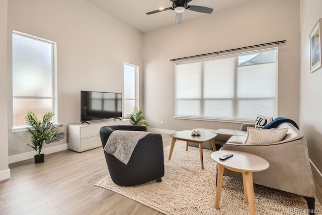 living room with baseboards, plenty of natural light, and light wood-style floors