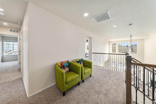 sitting room with carpet floors, attic access, baseboards, and visible vents