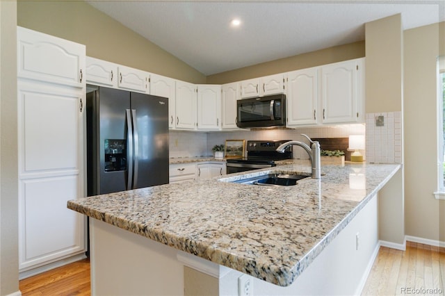 kitchen featuring white cabinets, backsplash, kitchen peninsula, and appliances with stainless steel finishes