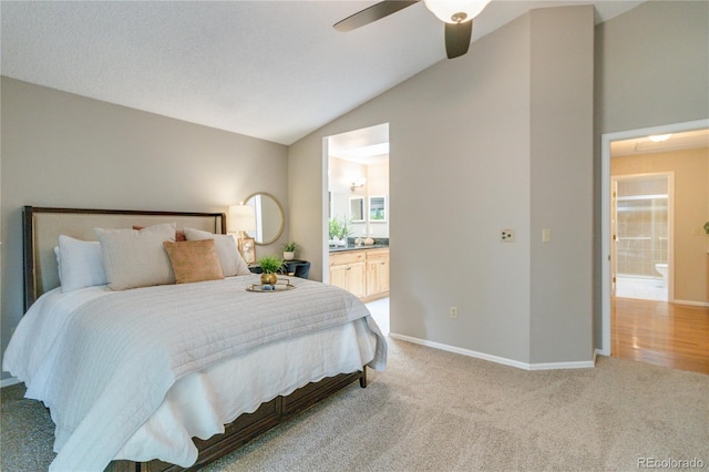 bedroom featuring ceiling fan, connected bathroom, light colored carpet, and lofted ceiling