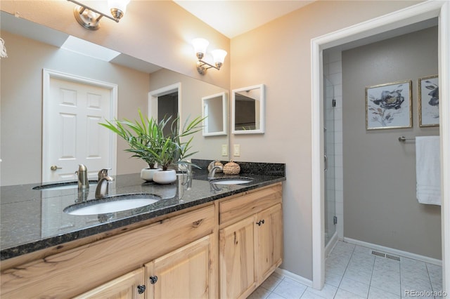 bathroom with tile patterned flooring, a shower with shower door, and vanity