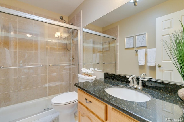 bathroom with tile patterned floors, toilet, vanity, and walk in shower