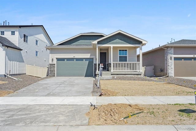 317 W Owen Ave, Keenesburg, CO 80643 - view of front facade with a porch, an attached garage, concrete driveway, and stone siding