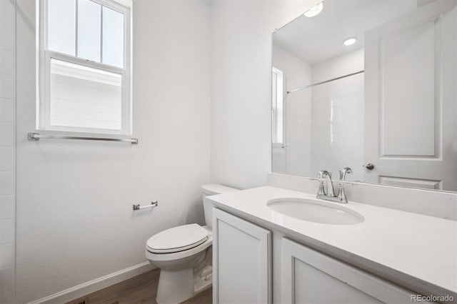317 W Owen Ave, Keenesburg, CO 80643 - full bath with toilet, baseboards, wood finished floors, vanity, and a shower