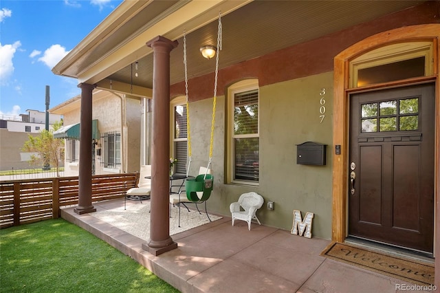 view of exterior entry featuring covered porch