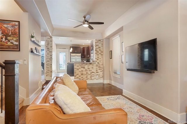 living room featuring dark wood-type flooring and ceiling fan