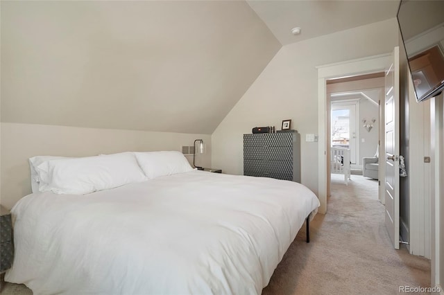 bedroom featuring lofted ceiling and light colored carpet