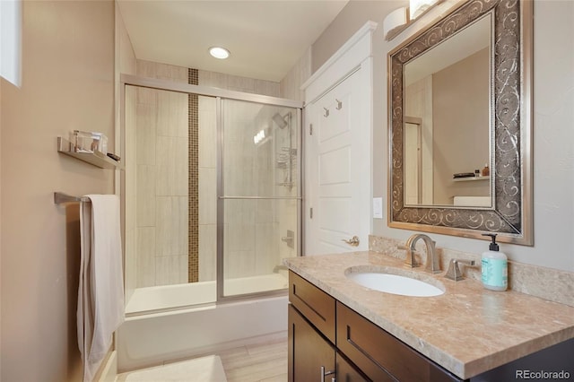 bathroom with vanity, bath / shower combo with glass door, and wood-type flooring