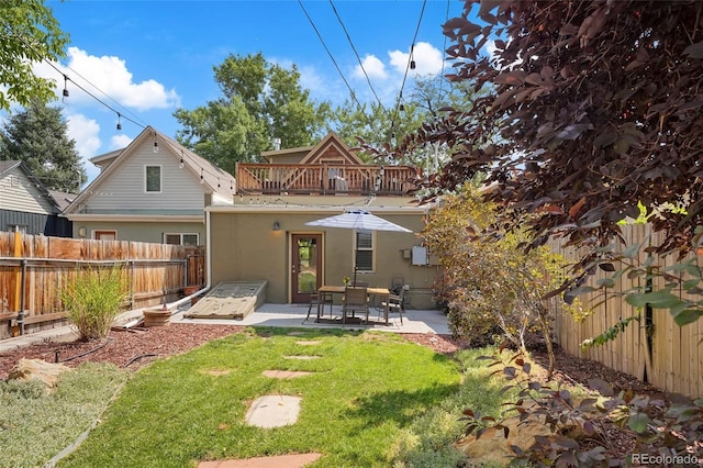 rear view of property featuring a yard and a patio area