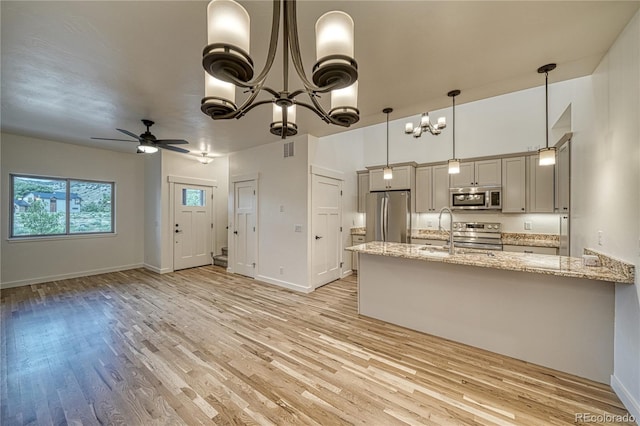 kitchen with sink, appliances with stainless steel finishes, light wood-type flooring, and hanging light fixtures