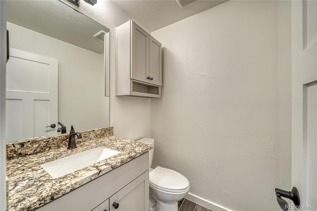 bathroom featuring hardwood / wood-style floors, vanity, and toilet